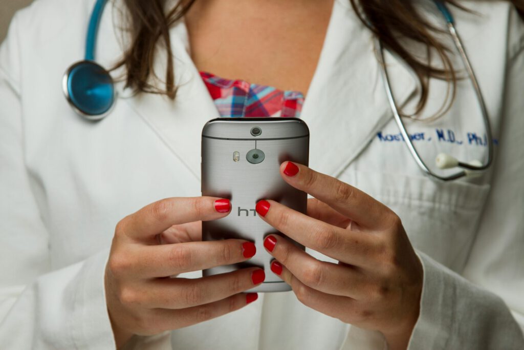 Doctor Eine Aufnahme einer Ärztin mit Kittel und einem grauen HTC.