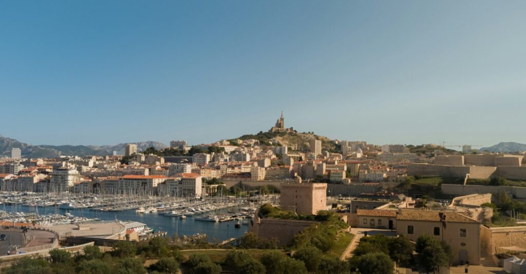 Marseille Eine Aufnahme vom Hafenbecken in Marseille mit Notre-Dame de la Garde im Hintergrund