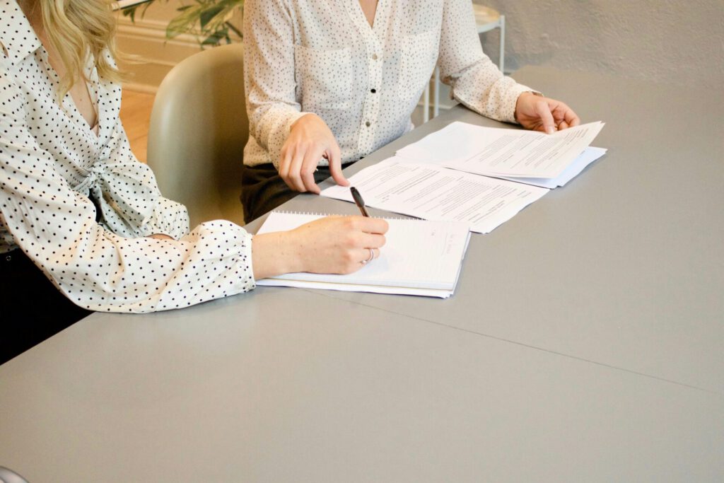 Papers Eine Aufnahme von zwei Frauen, die sich über Dokumente unterhalten.