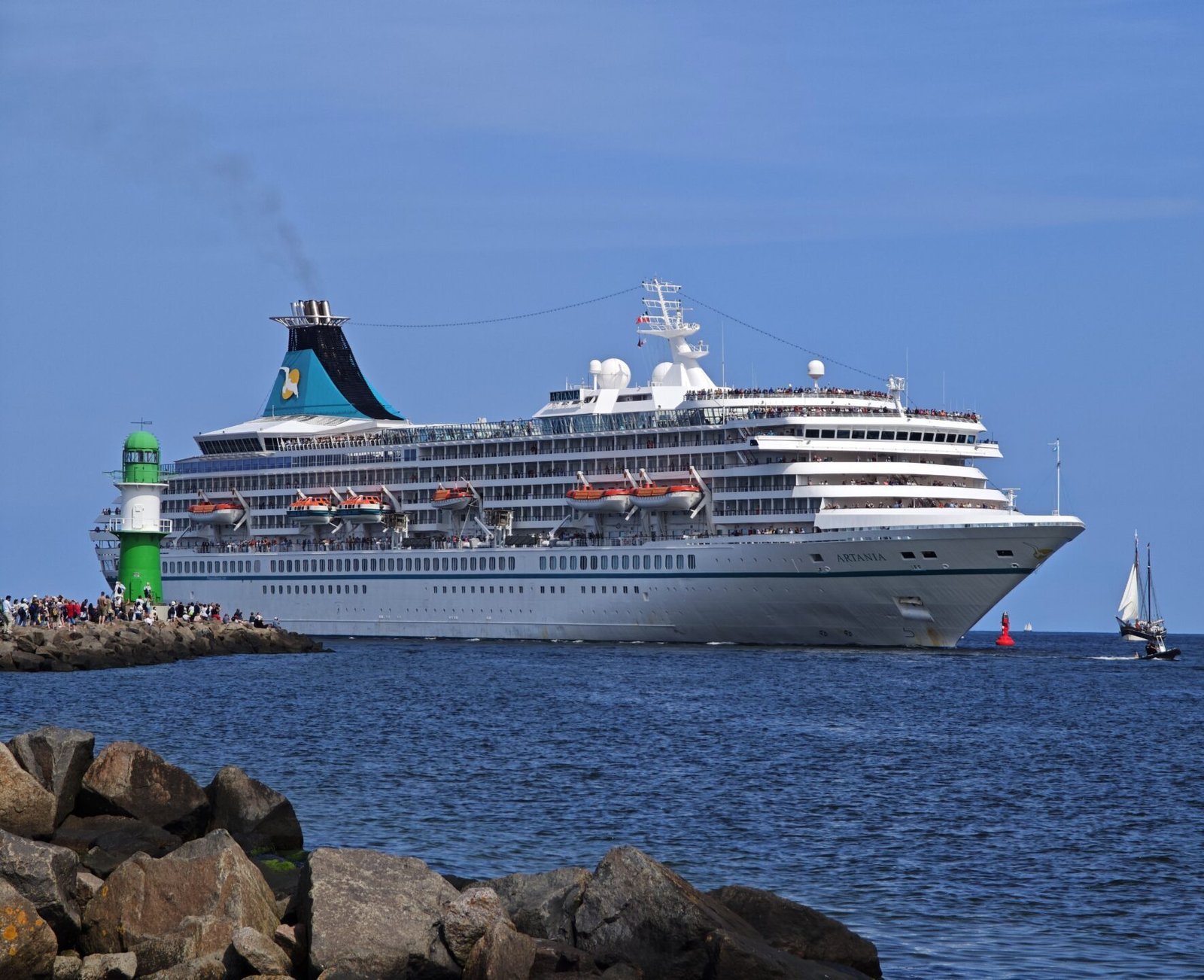 Eine Aufnahme der MS Artania von Phoenix Reisen beim Passieren der Westmole in Warnemünde, 2025.